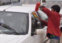 أطفال ومراهقون يتنافسون على مسح زجاج السيارات