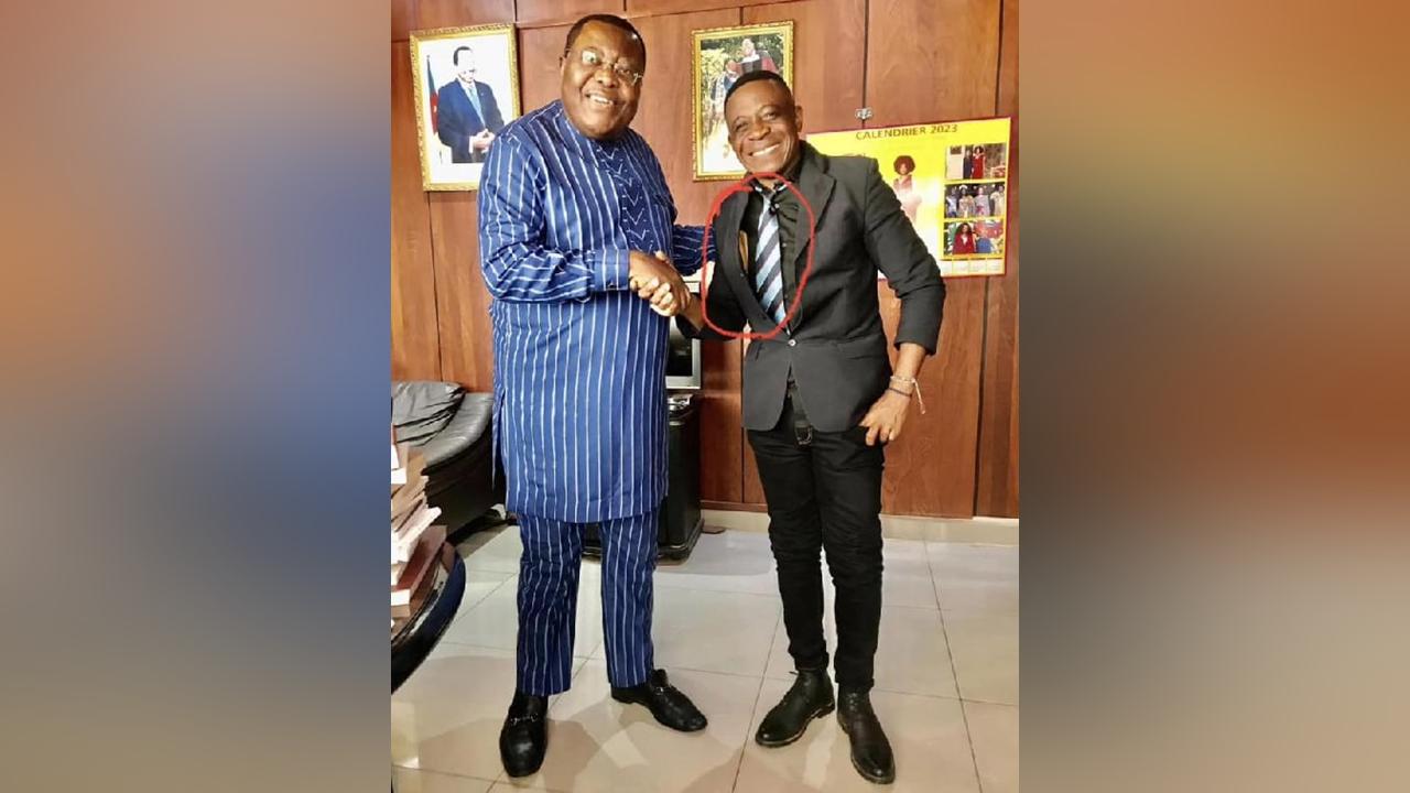 Enveloppe bourrée d’argent sous la veste : une photo de Sam Severin Ango chez Jean de Dieu Momo devient virale Enveloppe bourrée d’argent sous la veste : une photo de Sam Severin Ango chez Jean de Dieu Momo devient virale