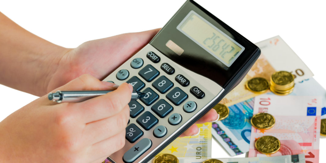 Hand mit Taschenrechner und Geld