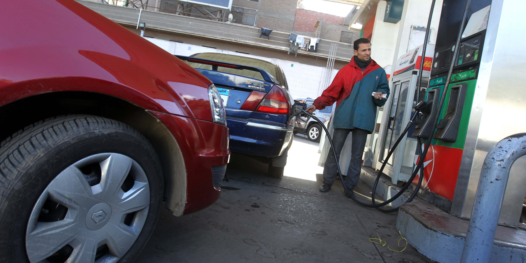An Egyptian worker fills a customer's ca